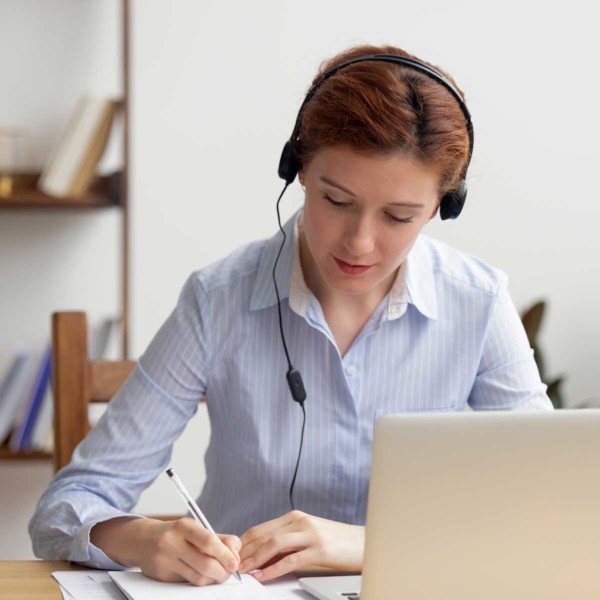 Image of someone with a headset using a laptop