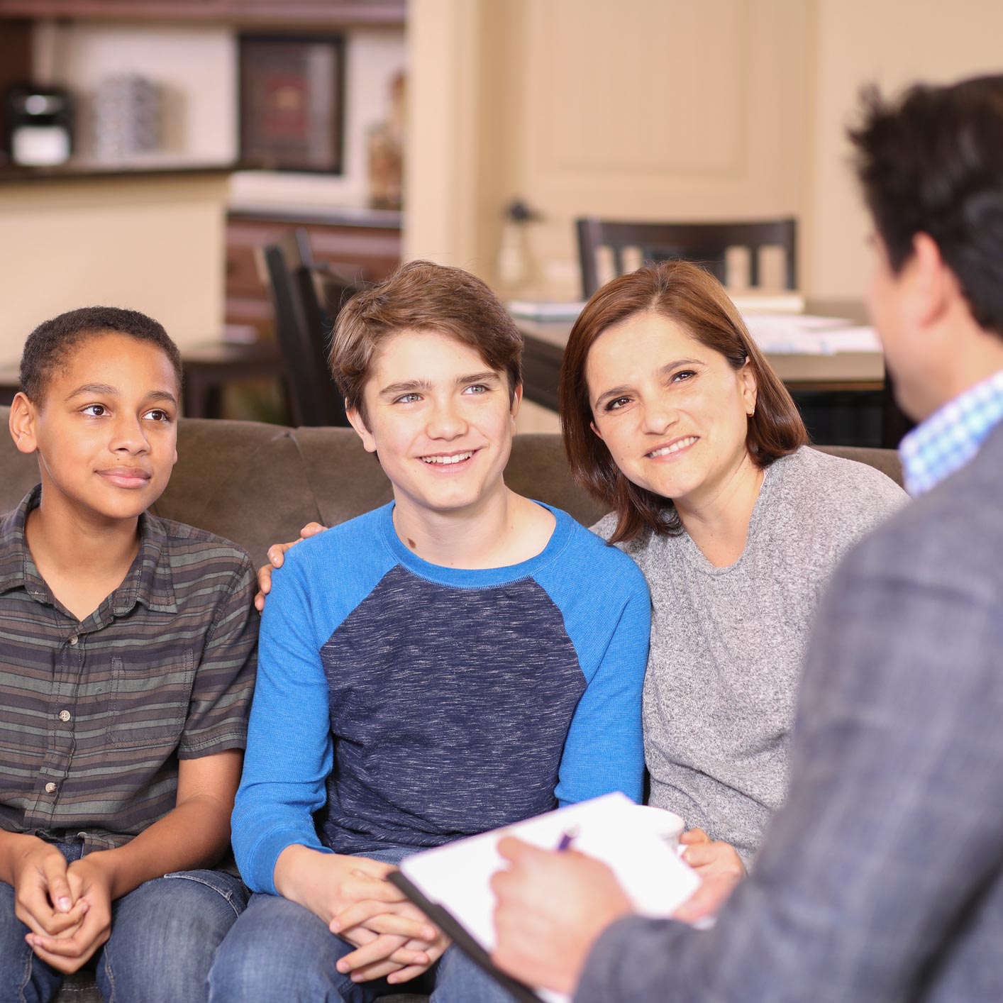 Adopted kids with their mom smiling on a couch