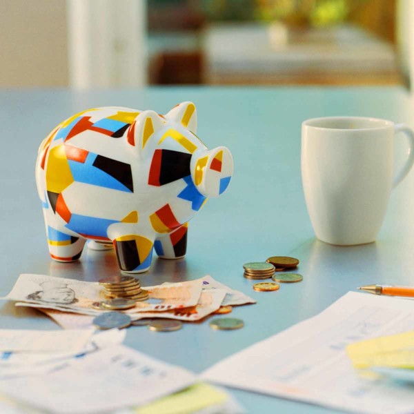 Colorful piggy bank with savings on the table