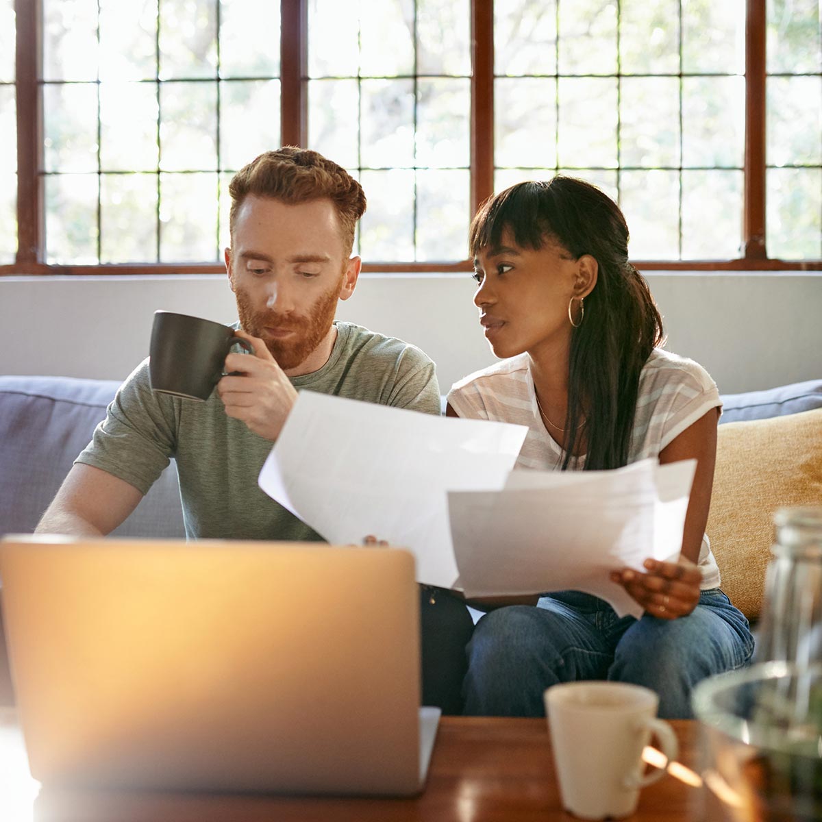 couple discussion adoption in their home on their couch while drinking coffee