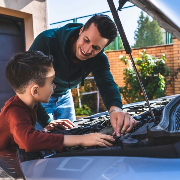 man showing son how to fix a car