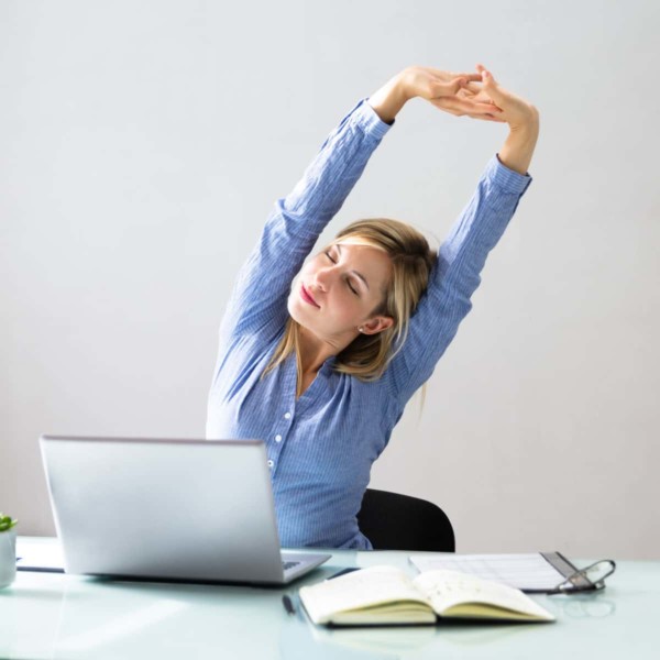 Image of someone stretching while at their desk.