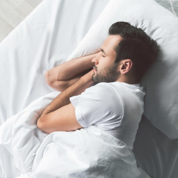 Image of someone laying in bed asleep.