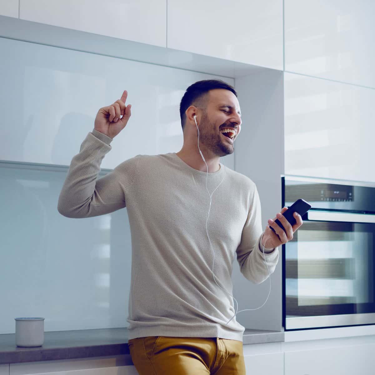 man listing to music, dancing, and happy