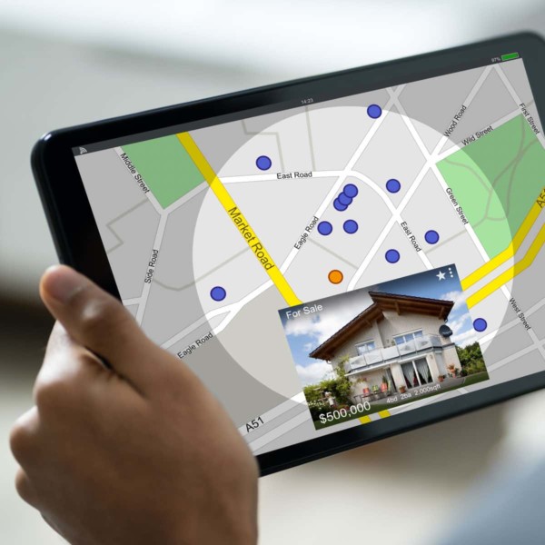 Someone using a tablet to look at houses in the area on a map