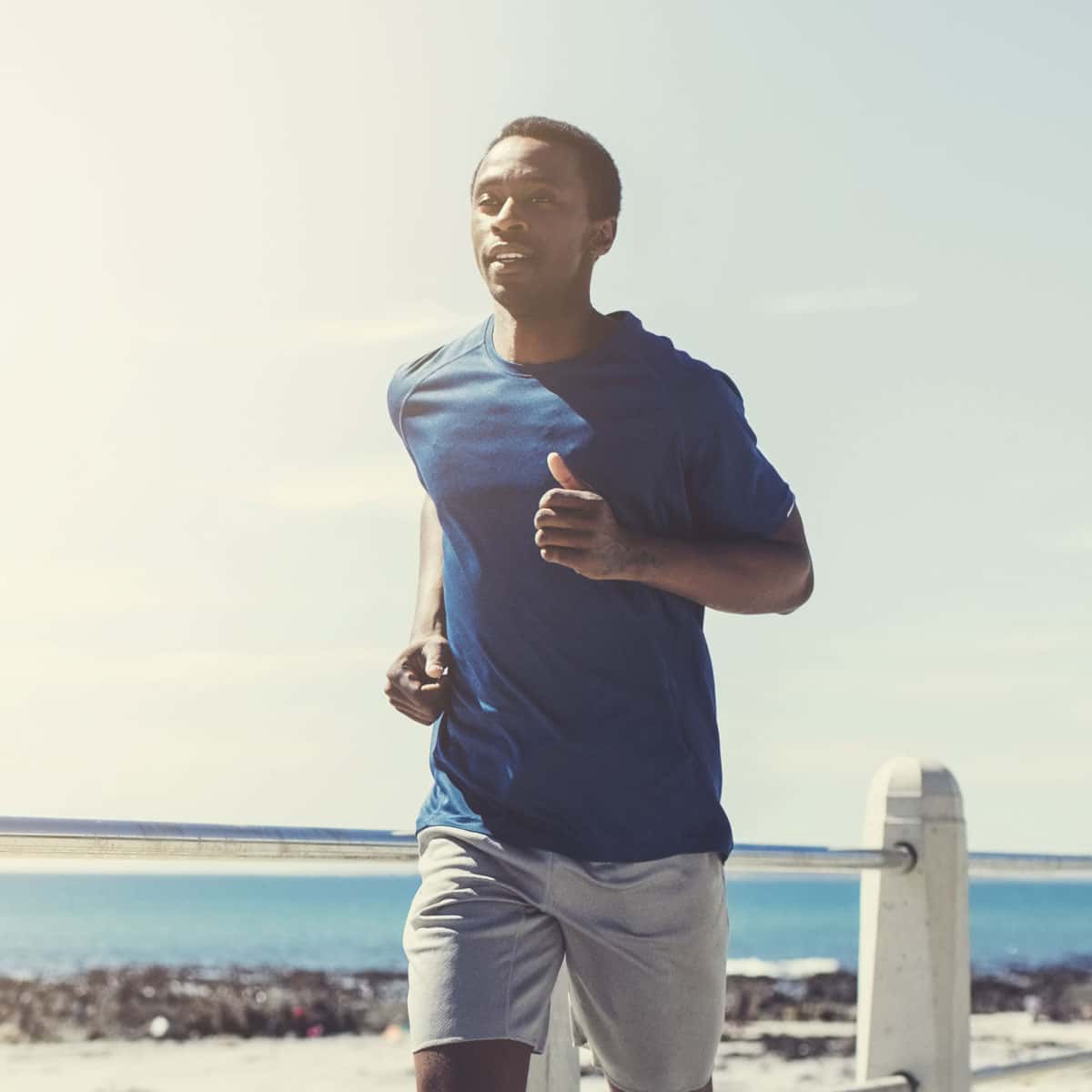 man running along a beach boardwalk