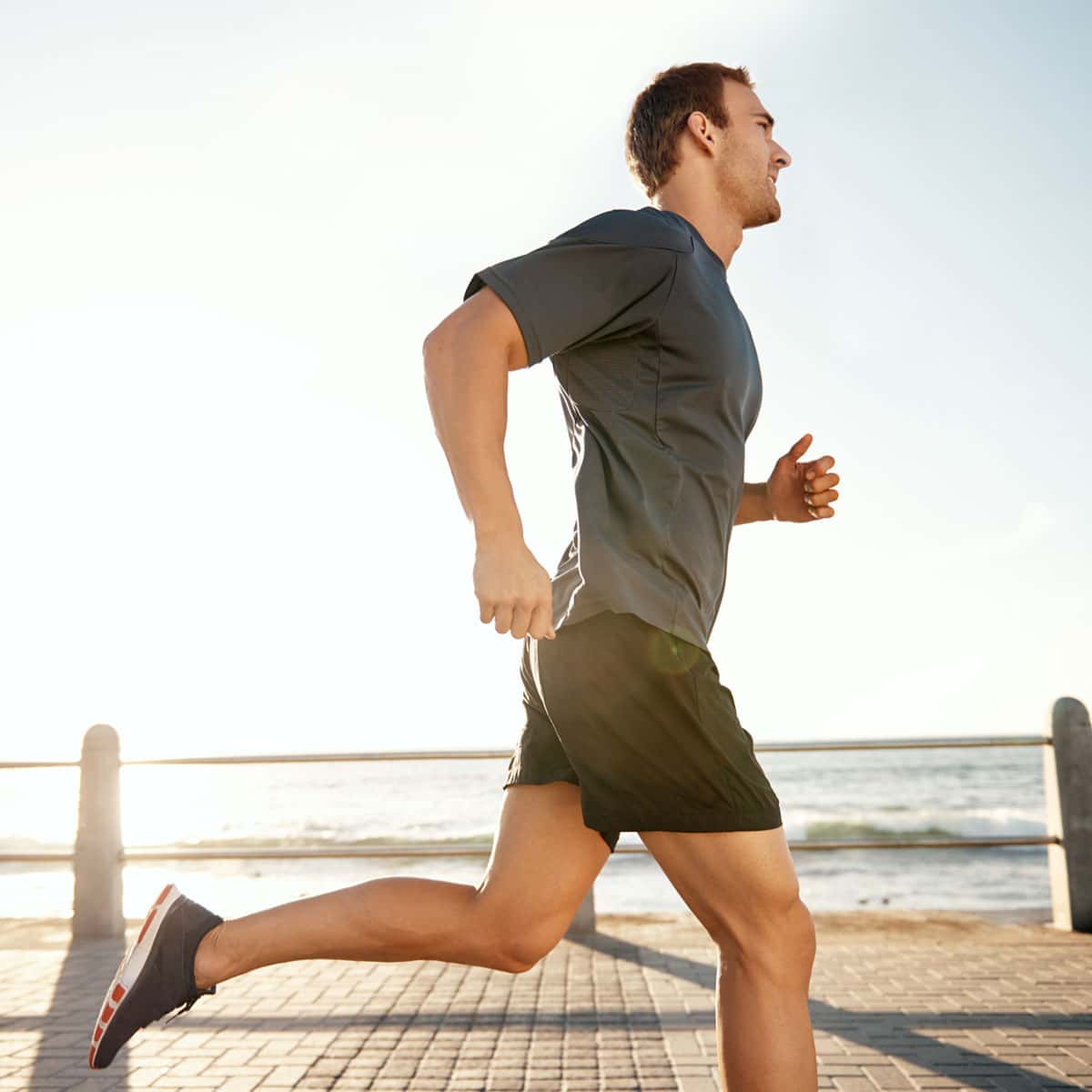 man running along the beach on the boardwalk