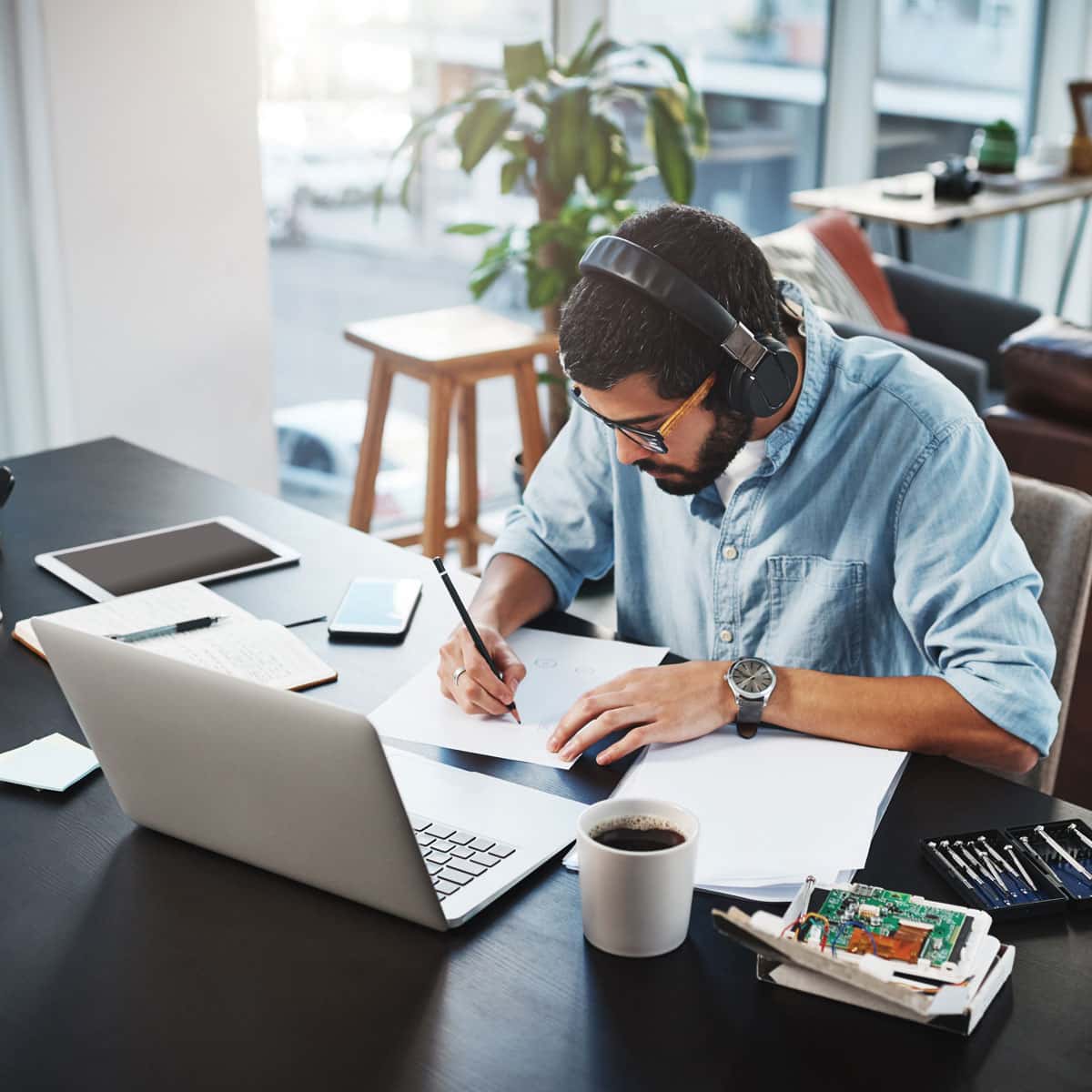man working at his desk at home with coffee