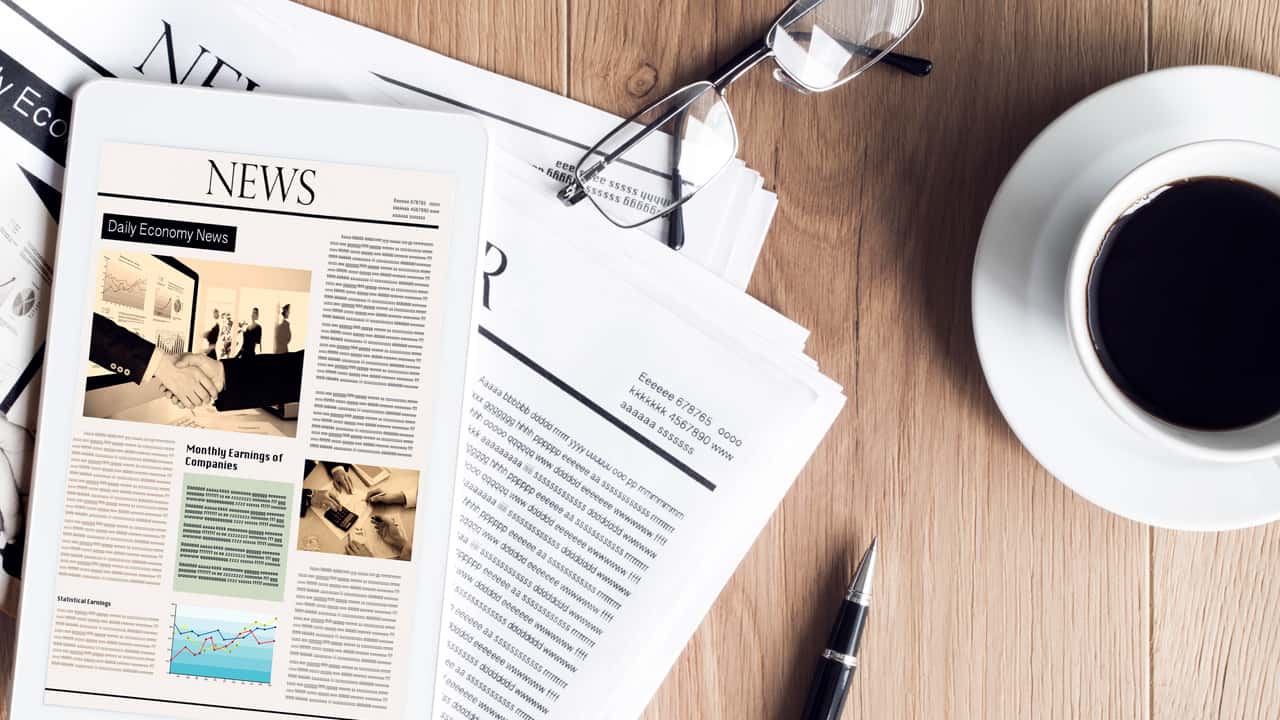 Image of a news article on a table next to a cup of coffee.