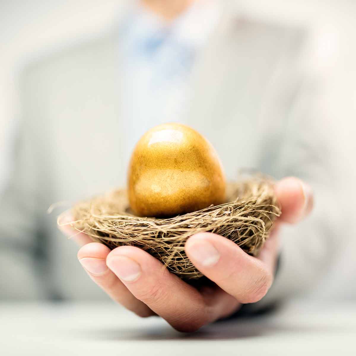man holding a golden egg in a nest