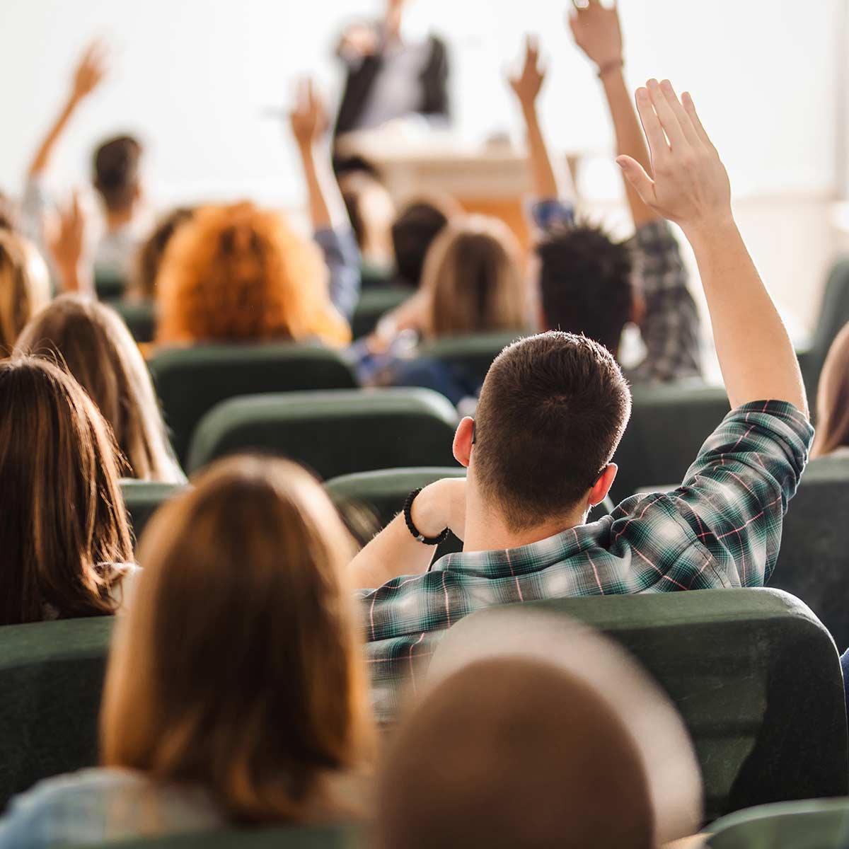 Image of multiple people raising their hands.