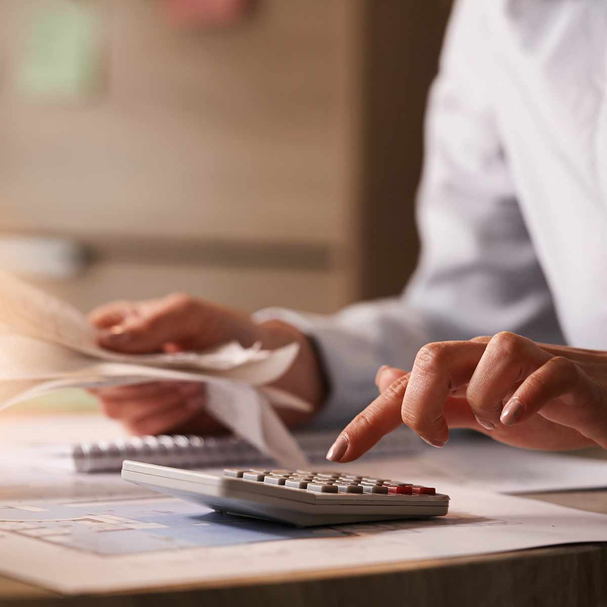 person reviewing receipts and using a calculator
