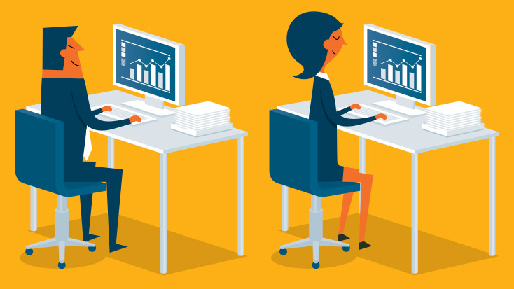 Image of two people sitting at desks working on computers.