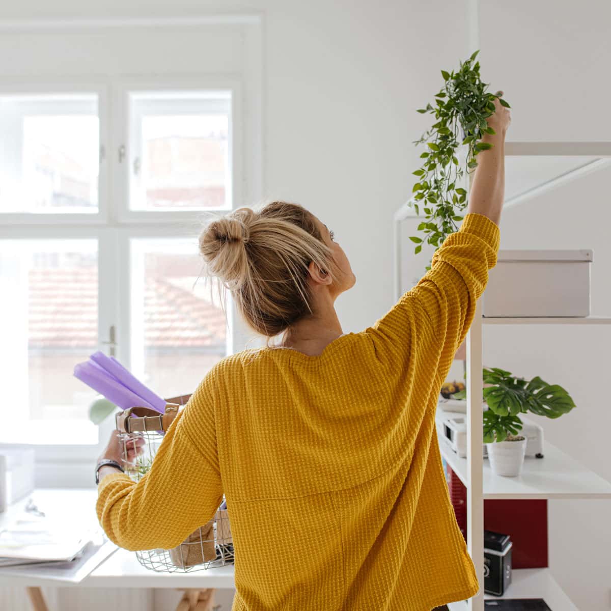 Woman decorating house with plants
