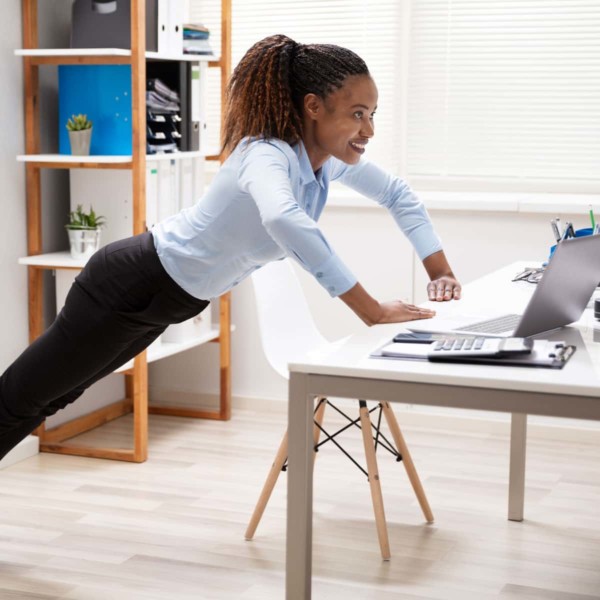 Woman exercising at her desk by doing push-ups