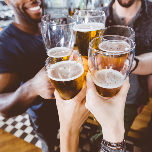 Group of friends hanging out and cheersing beers to celebrate friendship