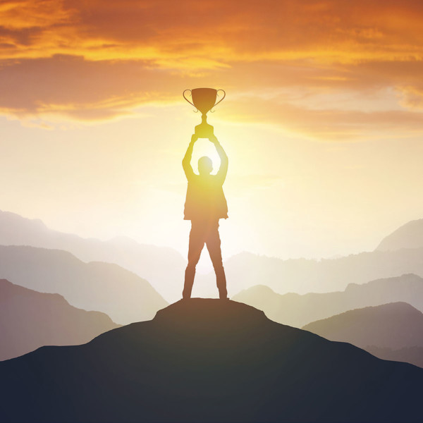 image of man successfully climbs mountain with trophy