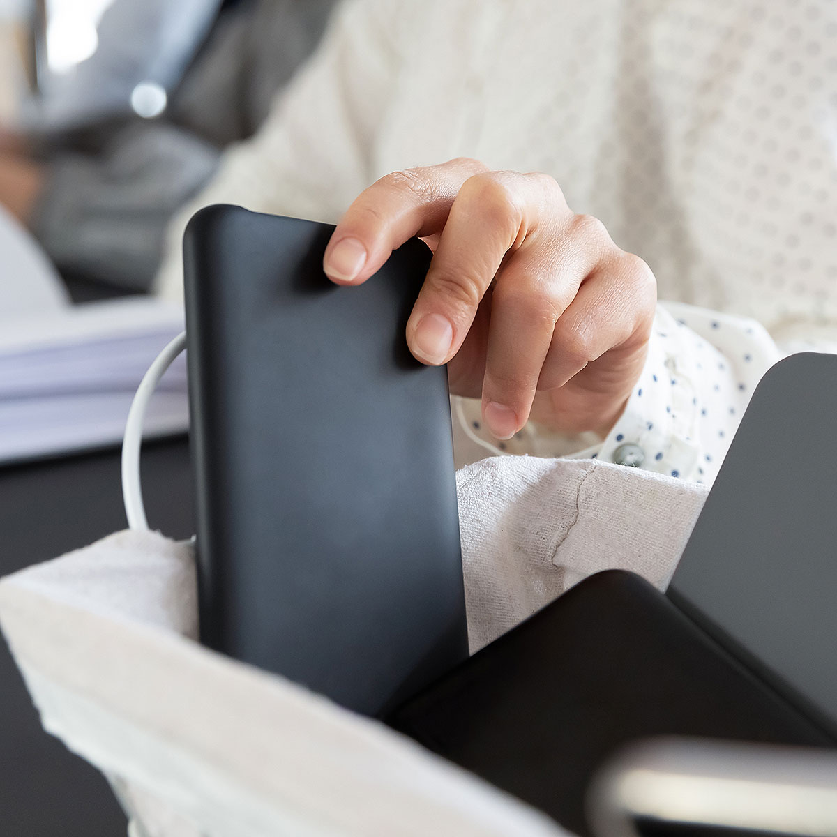image of person stowing away phone in bag