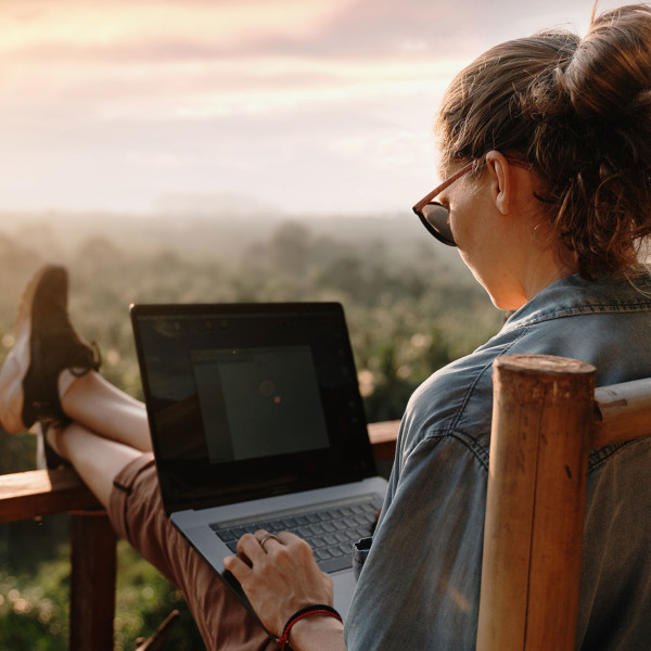 image of woman working on laptop with a scenic view