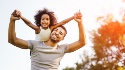 Image of father and daughter playing outside.