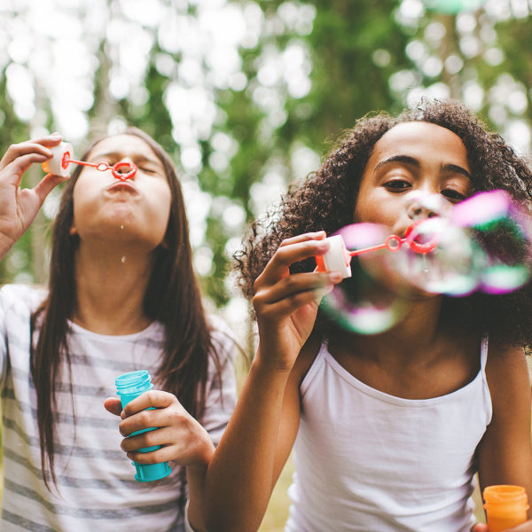 Image of two girls blowing bubbles.