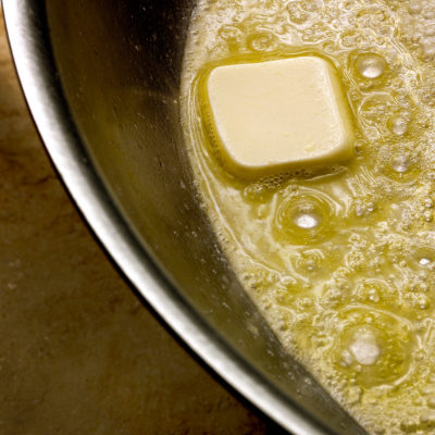 Butter and olive oil melting in saucepan to prep for chicken and rice