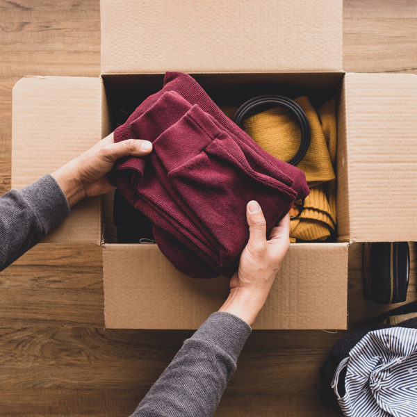 Putting folded pants in a donations box to give away